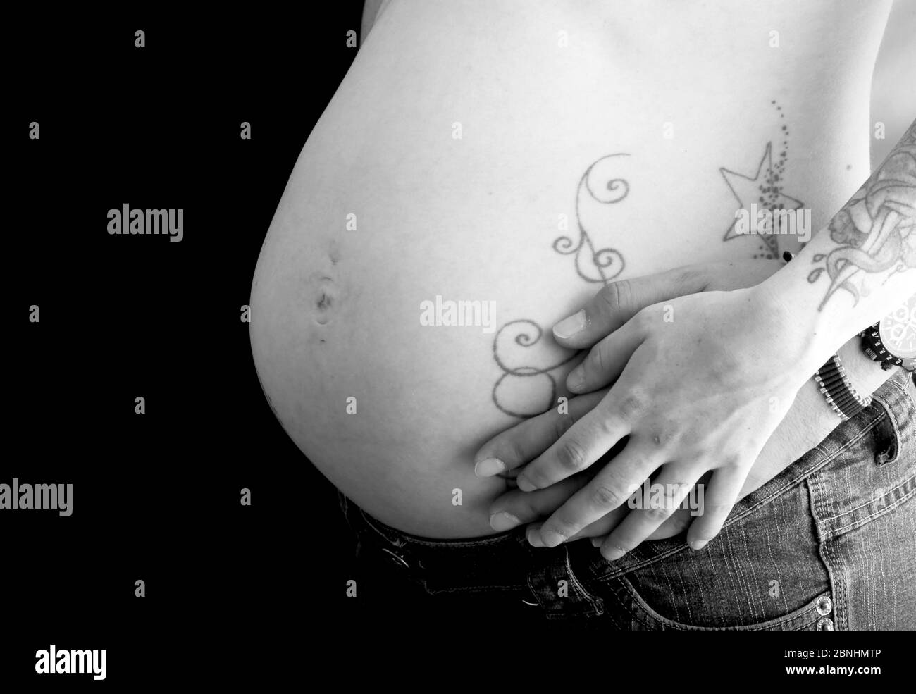 Une femme enceinte montre fièrement son ventre avec des tatouages. La mère  moderne à être était 9 mois dans la grossesse et a été bientôt de délivrer  un b sain Photo Stock -