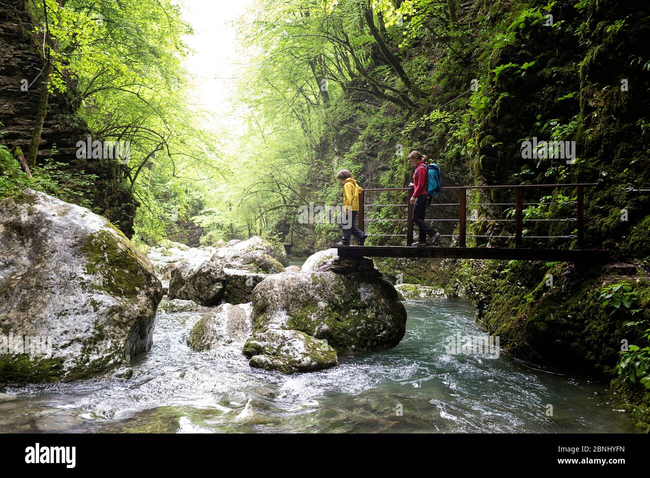 Mère et fils marchant dans les gorges de la rivière traversant le pont à la cascade de Kozjak, Slovénie Banque D'Images