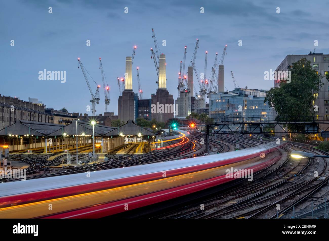 Longue exposition de train de voyageurs se rendant à la station électrique de Battersea, Londres, Angleterre, Royaume-Uni, Europe Banque D'Images