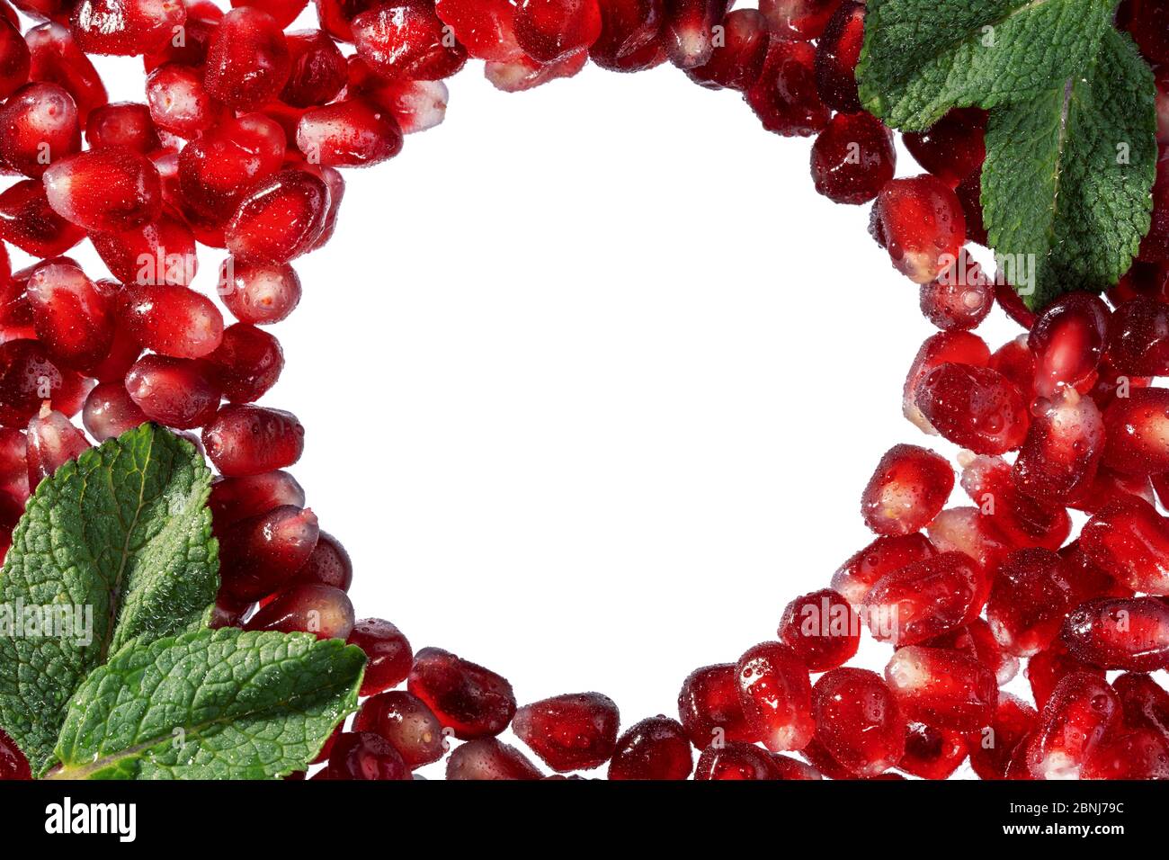 Grenade ou grenat rouge cadre de graines avec des feuilles de menthe isolées sur blanc. Mise en page créative du grenat à jus de graines. Plats chauds d'été. Tropi Banque D'Images