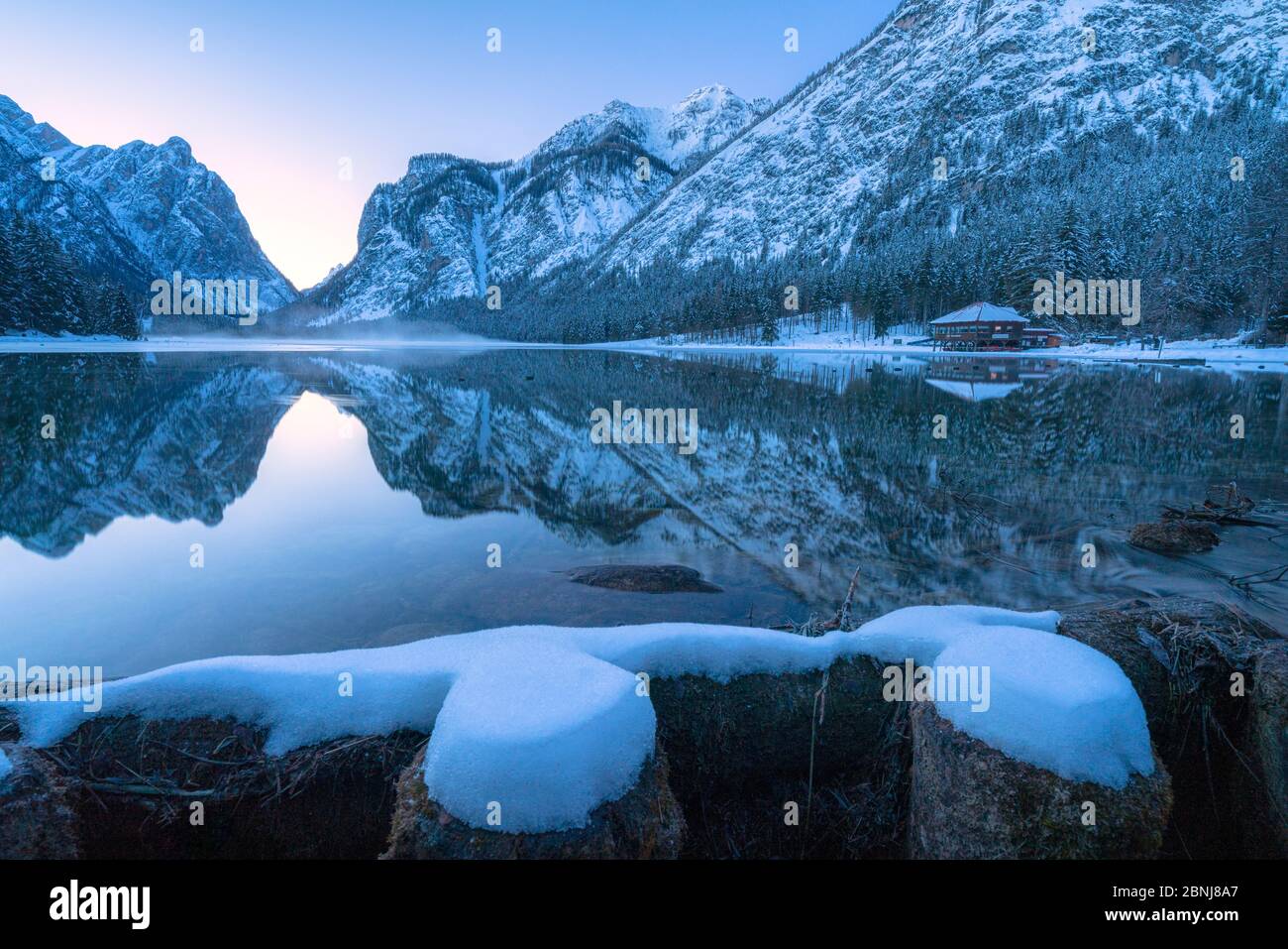 Crépuscule d'hiver sur le lac Dobbiaco entouré de neige, Dobbiaco, Val Pusteria, Dolomites, province de Bolzano, Tyrol du Sud, Italie, Europe Banque D'Images