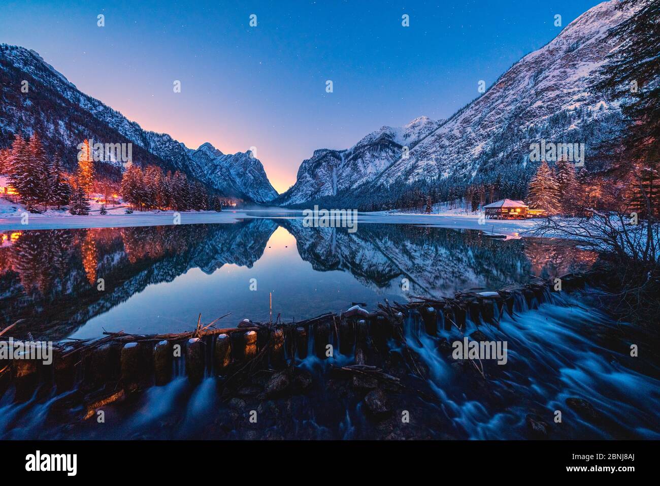 Lumières de crépuscule sur les sommets enneigés se reflétaient dans le lac Dobbiaco, Val Pusteria, Dolomites, province de Bolzano, Tyrol du Sud, Italie, Europe Banque D'Images