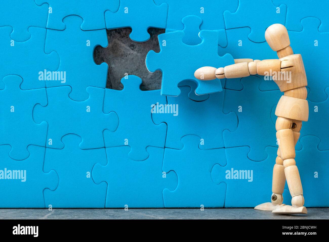 Homme en bois assemblant le dernier puzzle manquant sur le mur de puzzle.  Créer ou construire son propre concept d'entreprise Photo Stock - Alamy