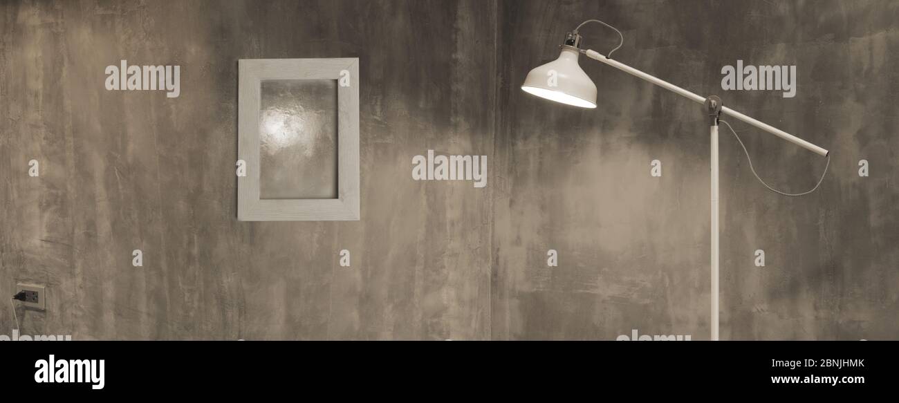 lampe blanche dans une pièce de style loft industriel en ciment gris foncé avec cadre photo bannière web d'arrière-plan moderne d'architecture d'intérieur Banque D'Images