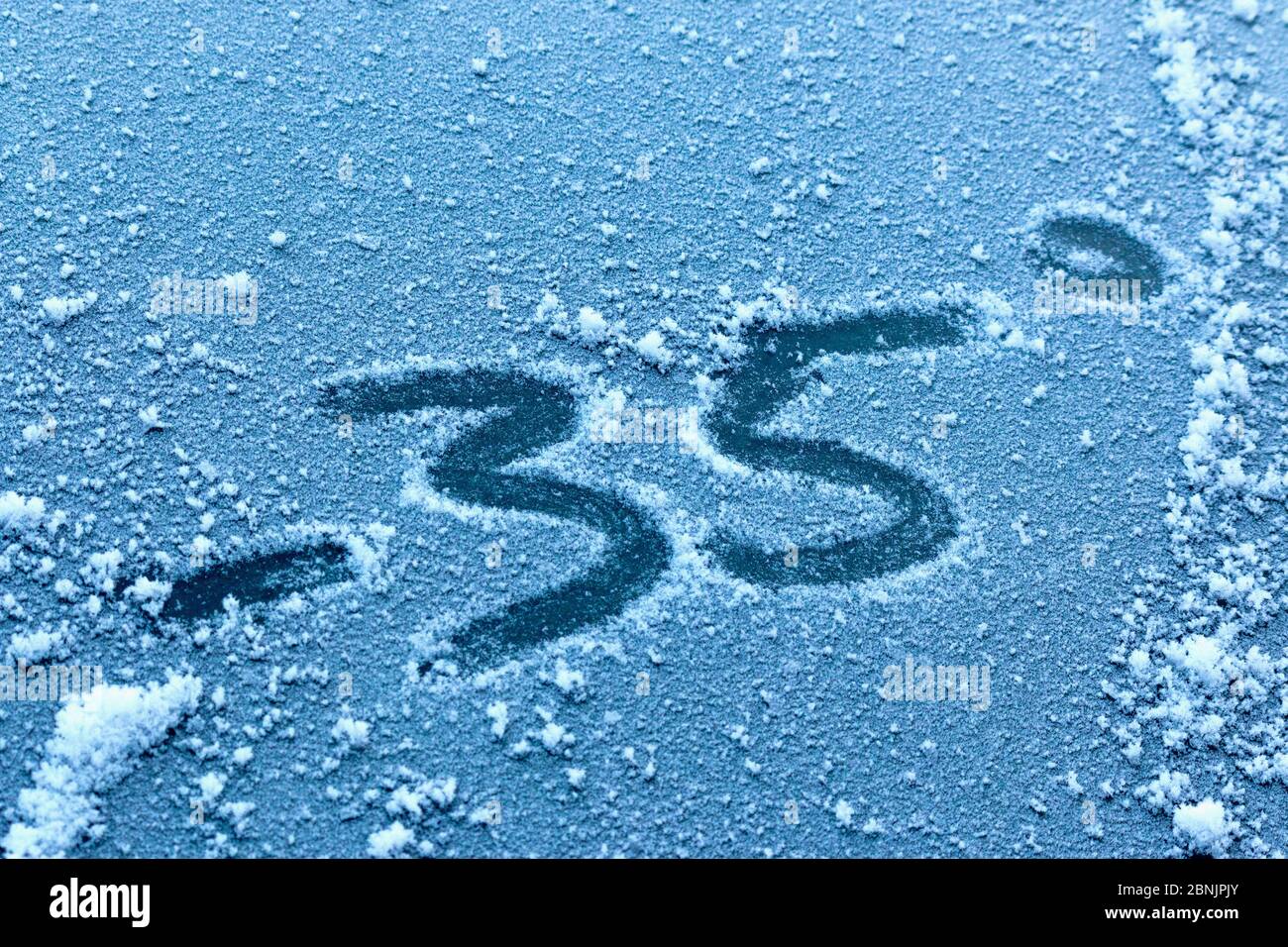 Pression anormale et froid d'hiver. L'inscription sur glace ou verre congelé est une température négative. Banque D'Images