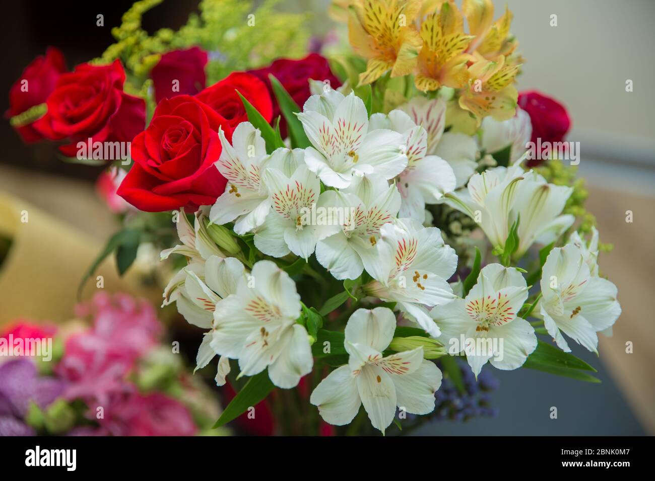 Contexte de la Saint-Valentin, jour du mariage. Les roses rouges fleuries fleurissent sur fond de bokeh hexagonal roué. Banque D'Images