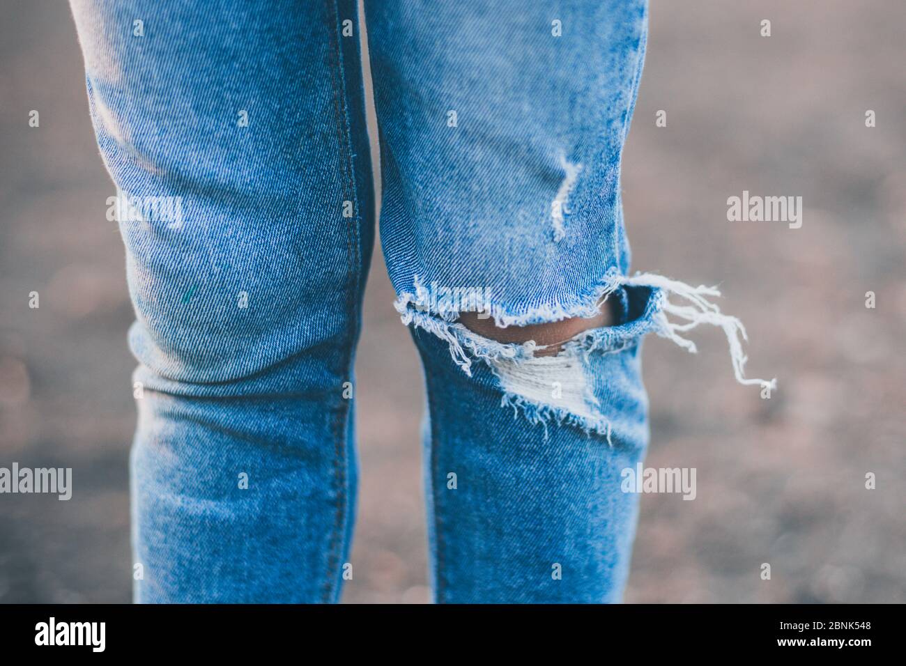 les jambes des filles sont en jeans dechires sur leurs genoux Photo Stock Alamy