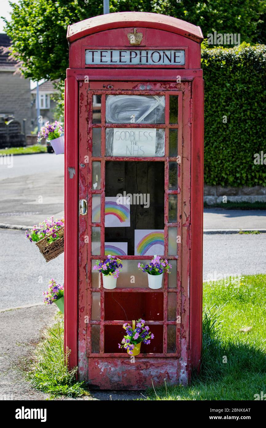 Des dessins arc-en-ciel (symbole de soutien pour les personnes qui veulent montrer leur solidarité avec les travailleurs du NHS) sont illustrés dans la boîte téléphonique de Chippenham Wilts Banque D'Images