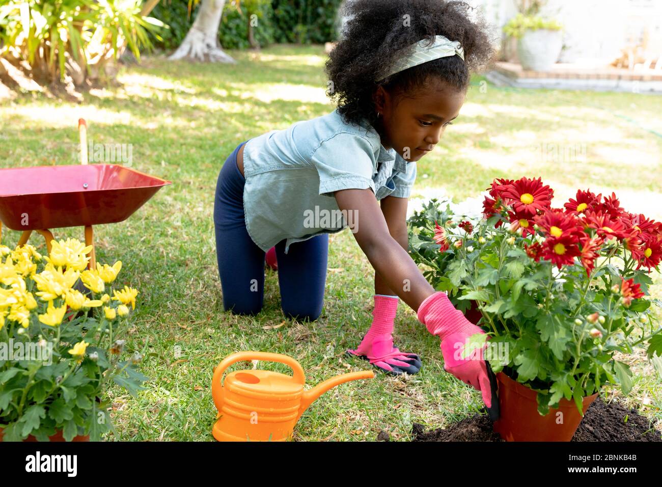 Fille afro-américaine plantant des fleurs. Banque D'Images