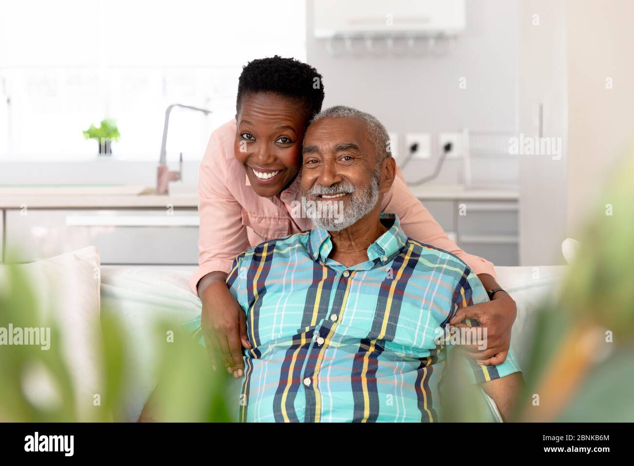 Couple afro-américain senior qui se fait embrasser, sourire et regarder la caméra Banque D'Images