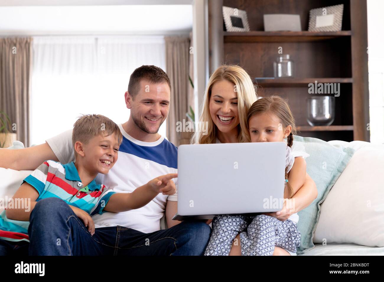 Famille caucasienne avec deux enfants utilisant un ordinateur portable à la maison Banque D'Images