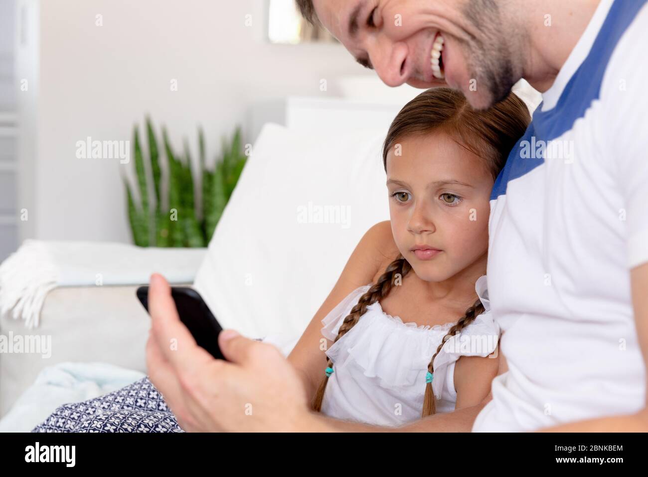 Une fille de race blanche et son père passent du temps ensemble à la maison Banque D'Images