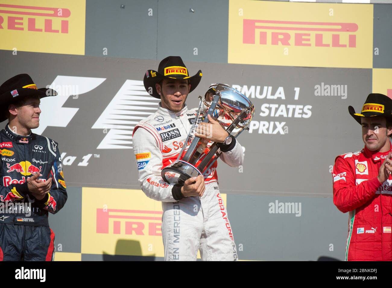 Austin Texas États-Unis, 18 novembre 2012 : le pilote gagnant Lewis Hamilton (c) détient le trophée entre Sebastian Vettel (l) et Fernando Alonso (r) sur le stand du gagnant lors de l'inauguration du Grand Prix des États-Unis de Formule 1 sur circuit des Amériques 3,2 miles. ©Bob Daemmrich Banque D'Images