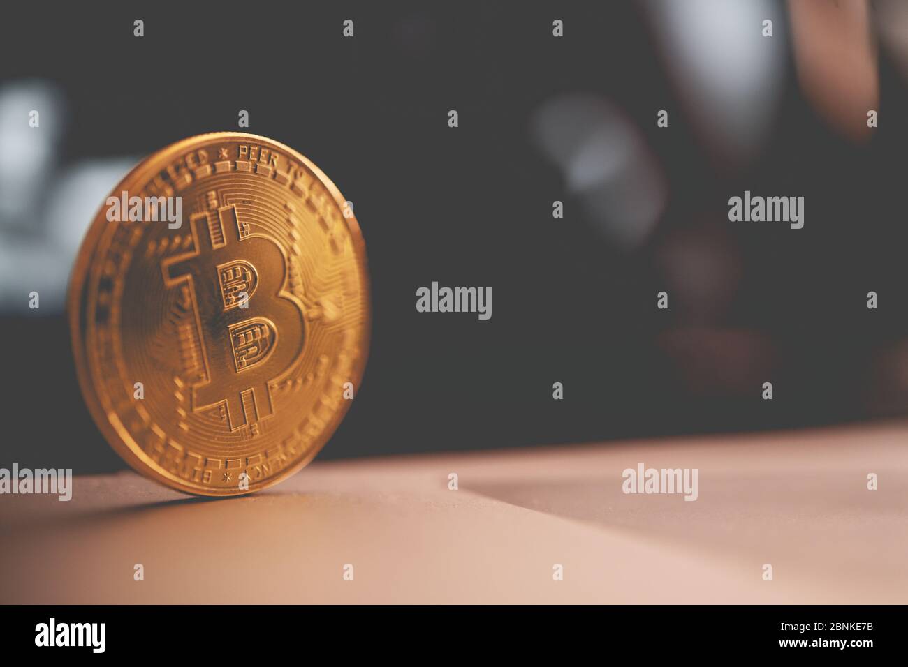 Gros plan de la brillante Golden Bitcoin Crypto monnaie Rolling sur la table en bois. Banque D'Images