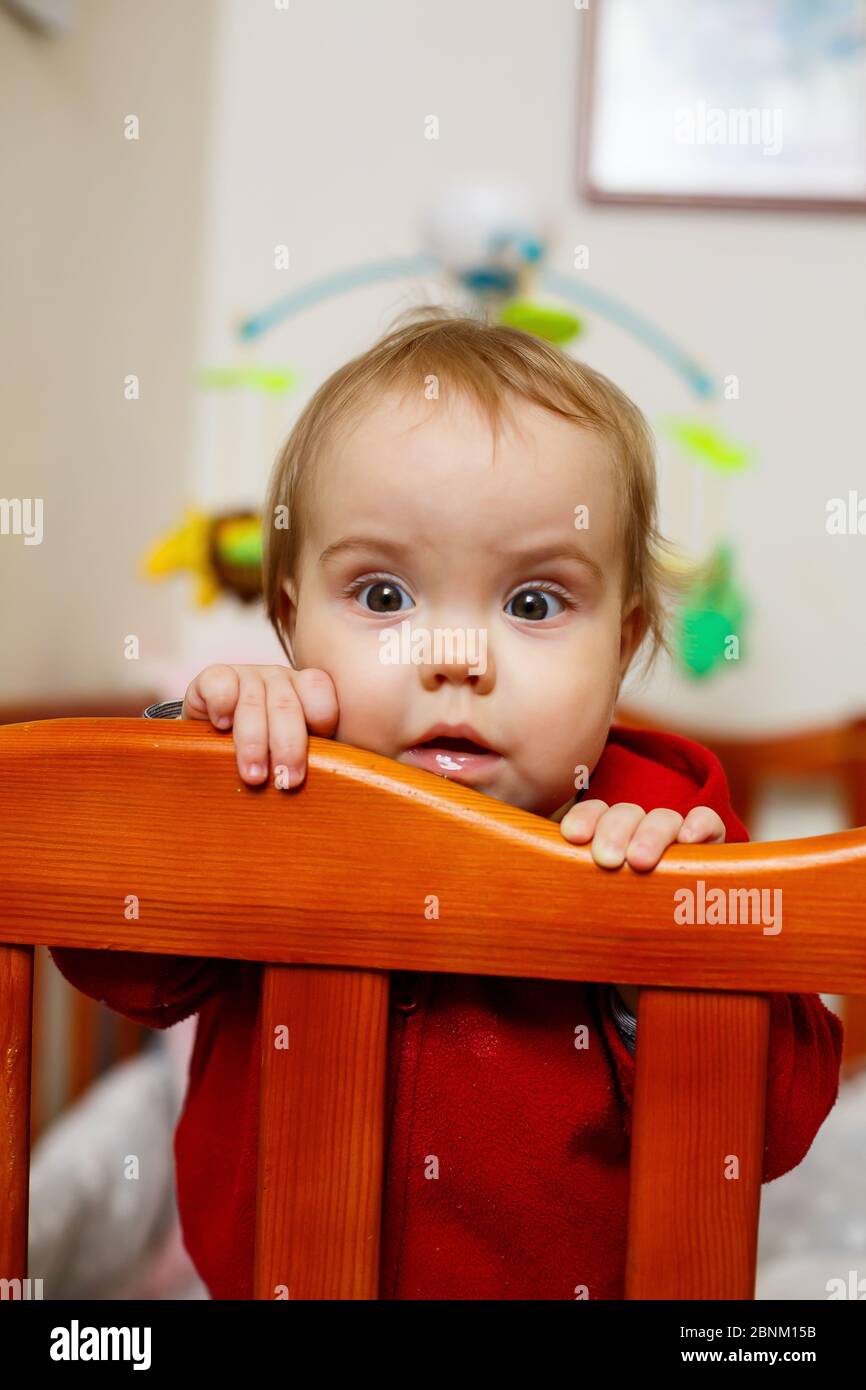 Petite Fille D Enfant Dans Un Pull Rouge Sourires Magnifiquement Dans Un Lit De Bebe Joue Et A Une Photo Amusante Et Emotionnelle Photo Stock Alamy