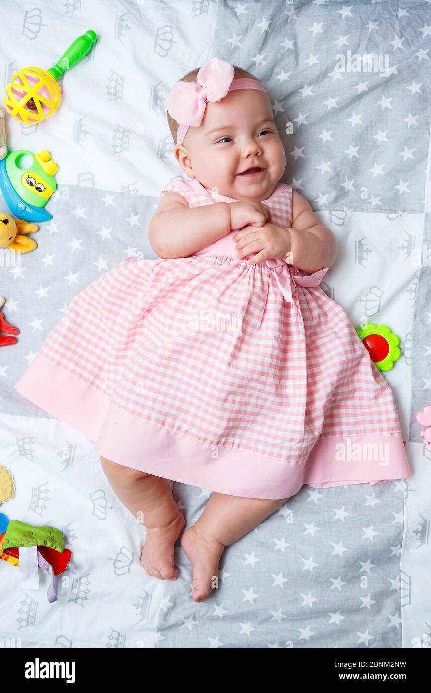 Bebe Fille De 3 Mois Est Couche Sur Le Lit Bebe Dans Une Robe Rose Et Un Bandeau Dans Une Couche Photo Stock Alamy
