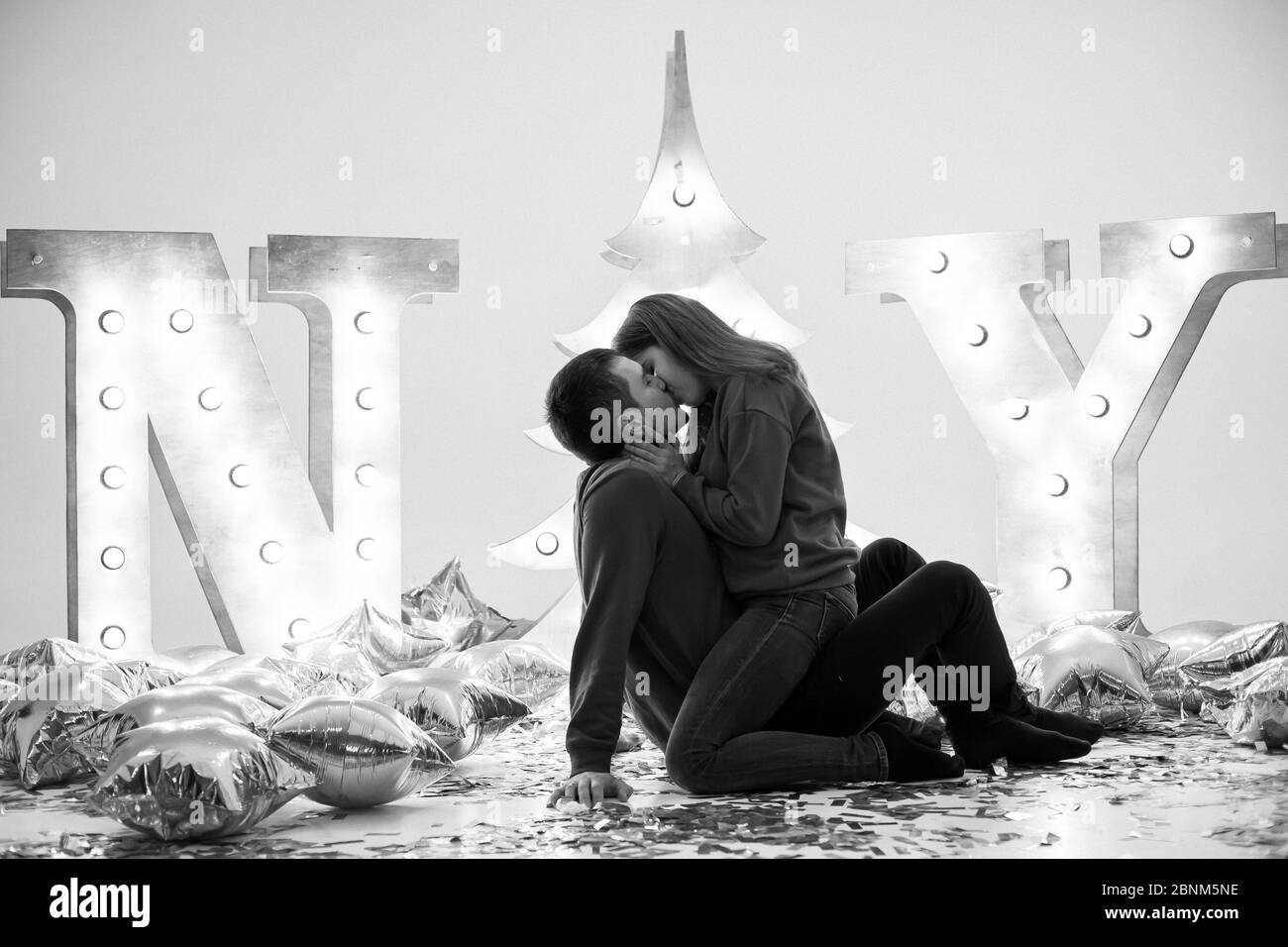 Un moment romantique. Un couple de chandails rouges repose sur le sol embrassant et embrassant Banque D'Images