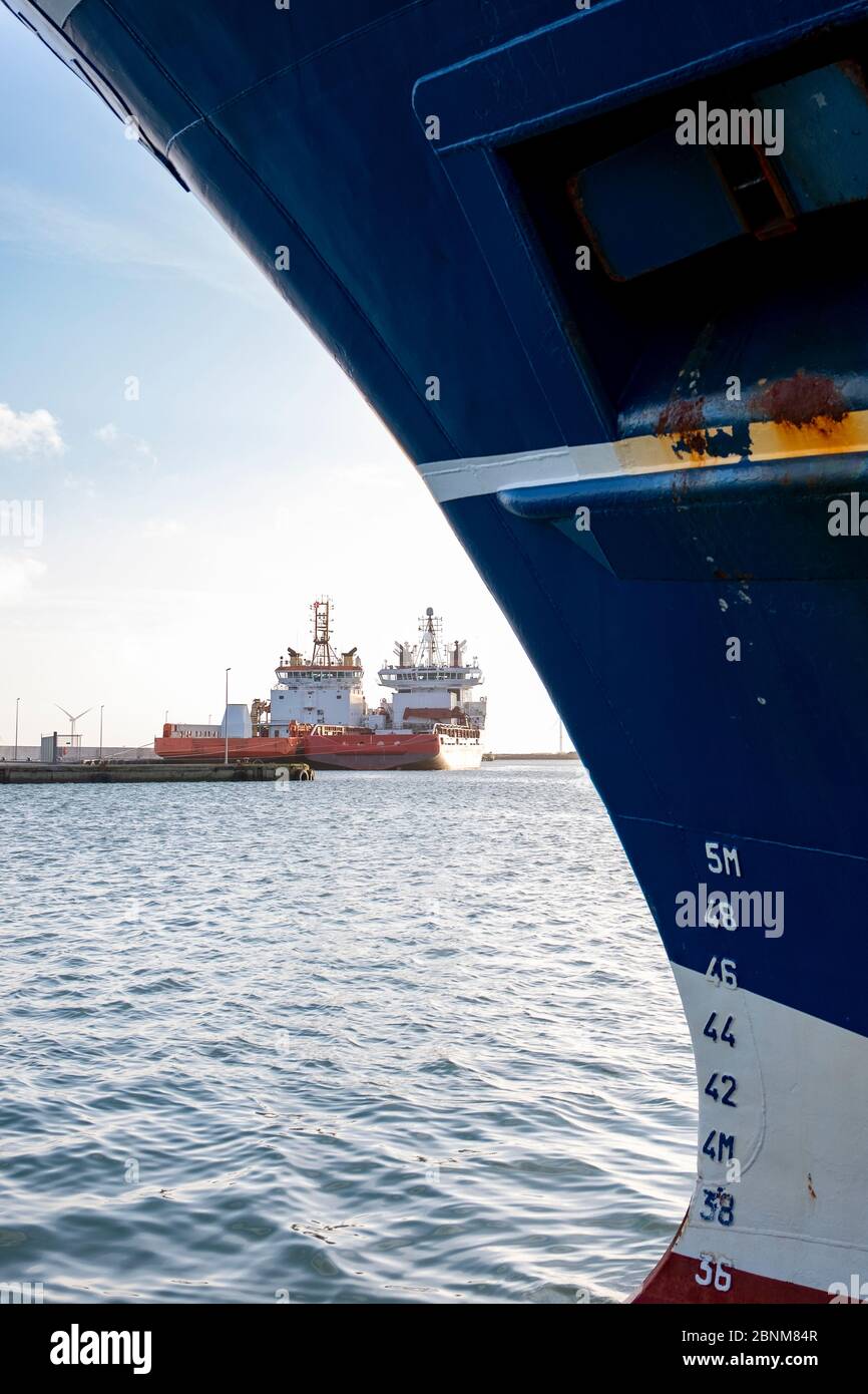 Port avec deux navires d'approvisionnement et arc d'une pêche en haute mer au premier plan. Banque D'Images