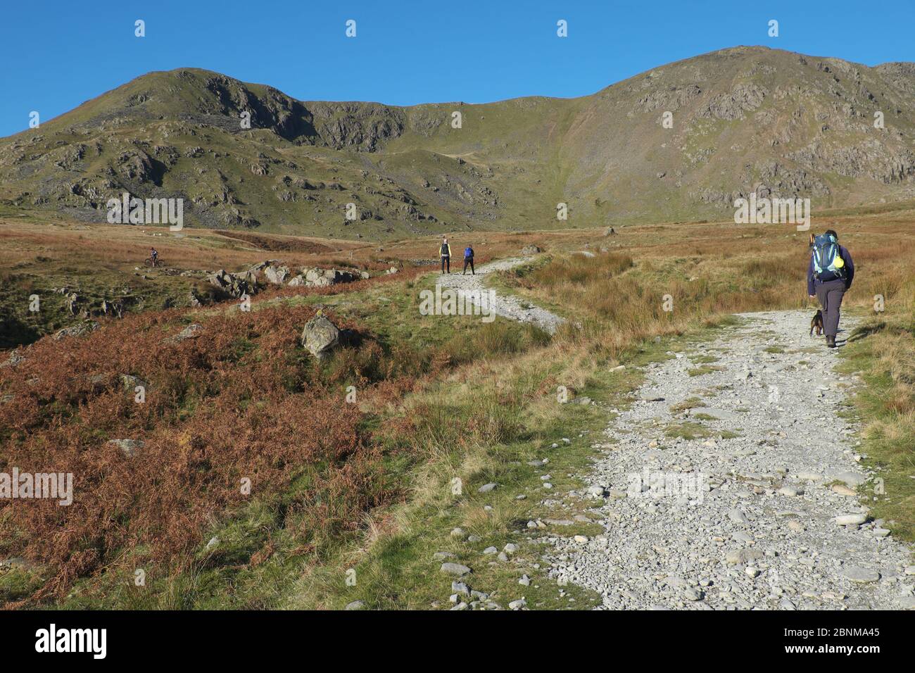 Marcheurs sur la route de Walna SCAR, un chemin restreint dans le parc national de Lake District, Cumbria, Angleterre. Banque D'Images