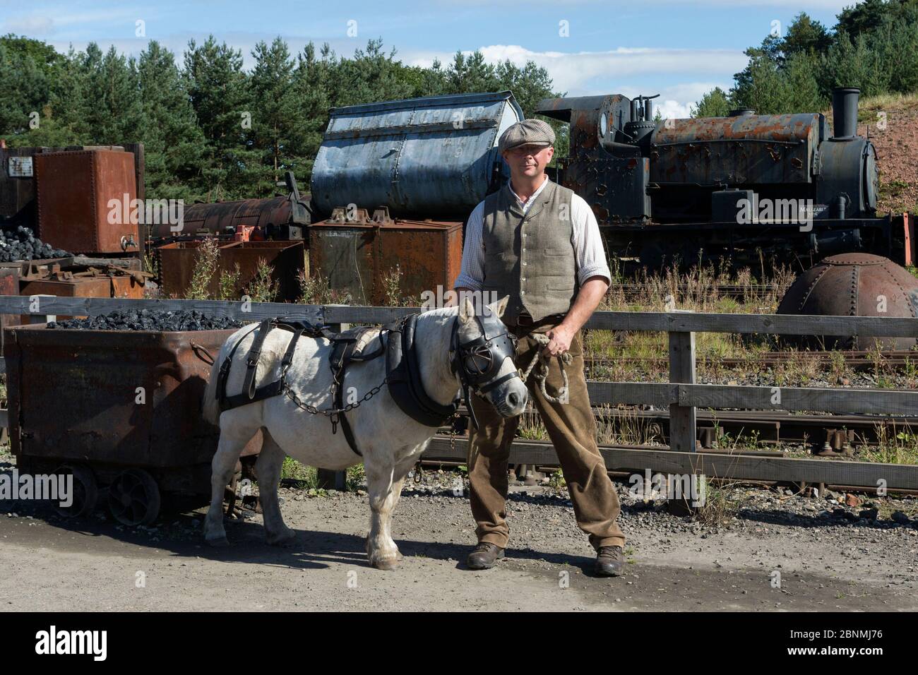 Le poney Shetland, en harnais minier complet, est dirigé par un mineur, à Beamish, le musée en plein air du nord de l'Angleterre, près de Stanley, comté de Durham, Angleterre, unité Banque D'Images