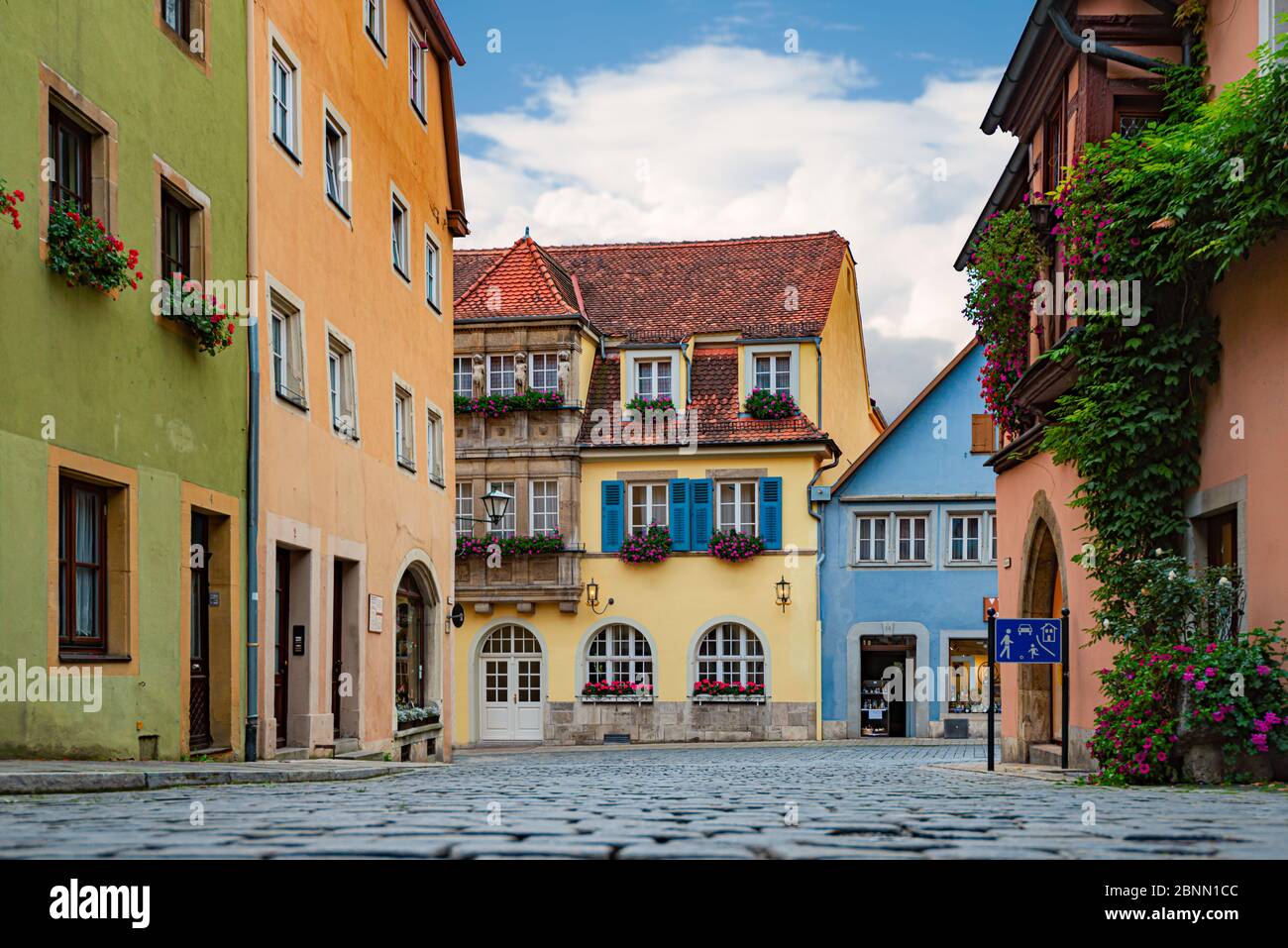 Ancienne rue vide à Rothenburg OB Der Tauber, Bavière, Allemagne, Europe. Ancienne architecture allemande. Ciel bleu ciel nuageux en arrière-plan Banque D'Images