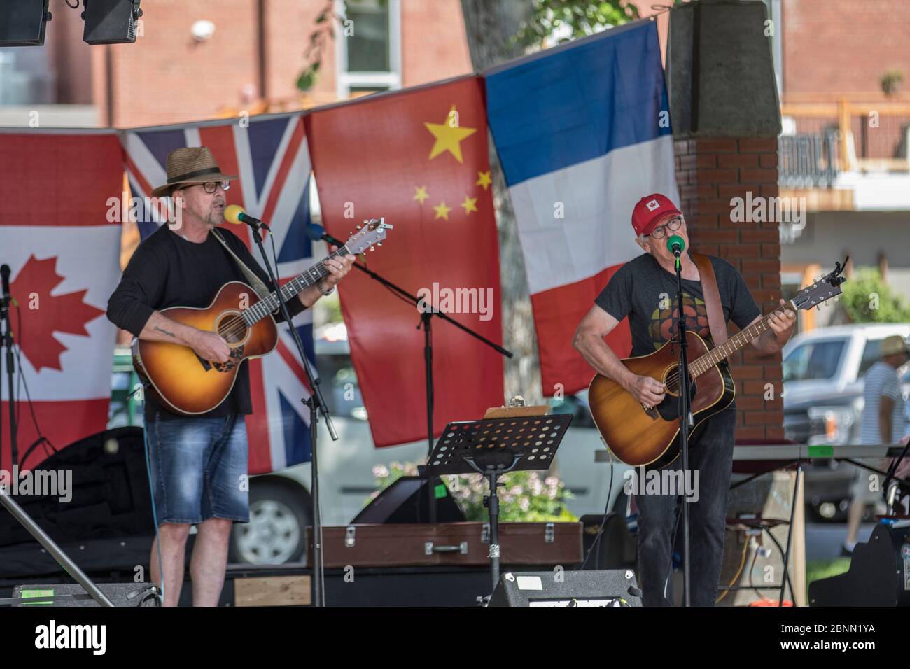 Festival multiculturel de Cranbrook, deux musiciens devant divers drapeaux. Banque D'Images