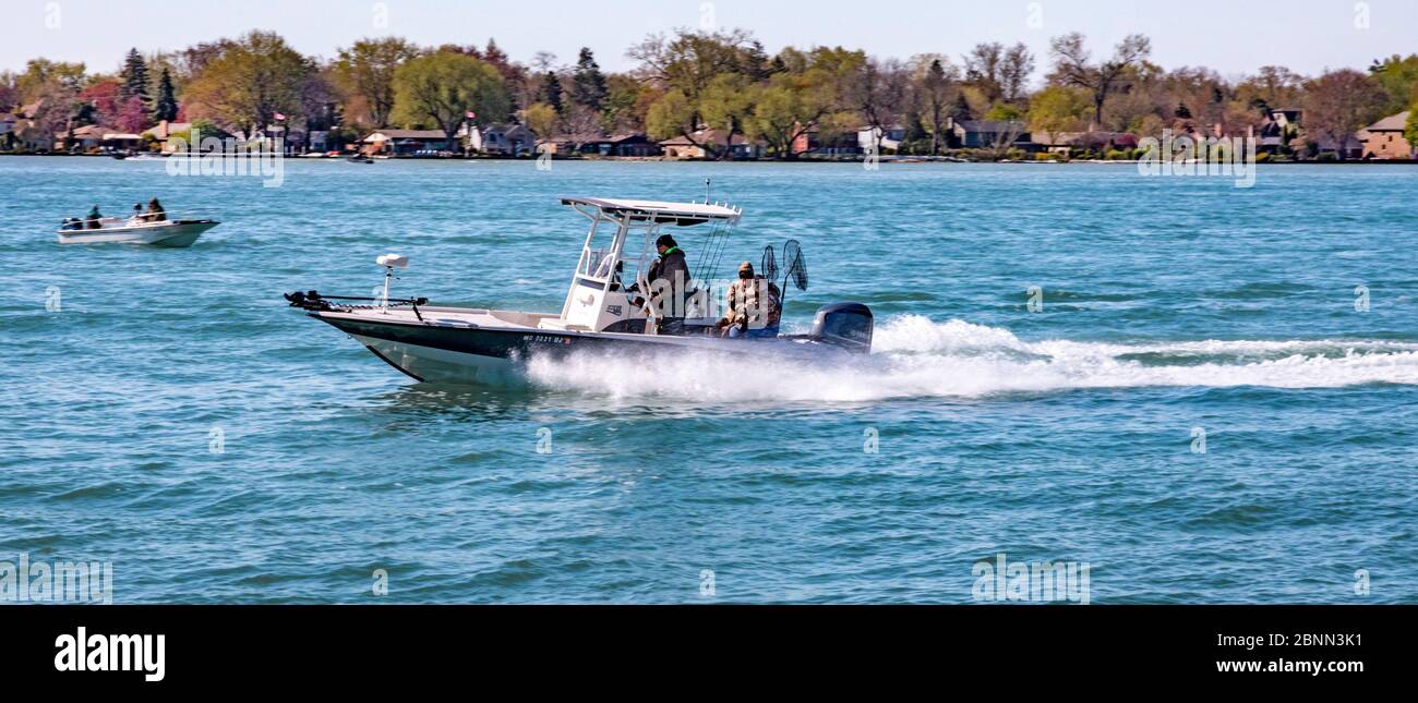 Detroit, Michigan - UN bateau de pêche sportive accélère la rivière Detroit le matin d'un printemps frais. Banque D'Images