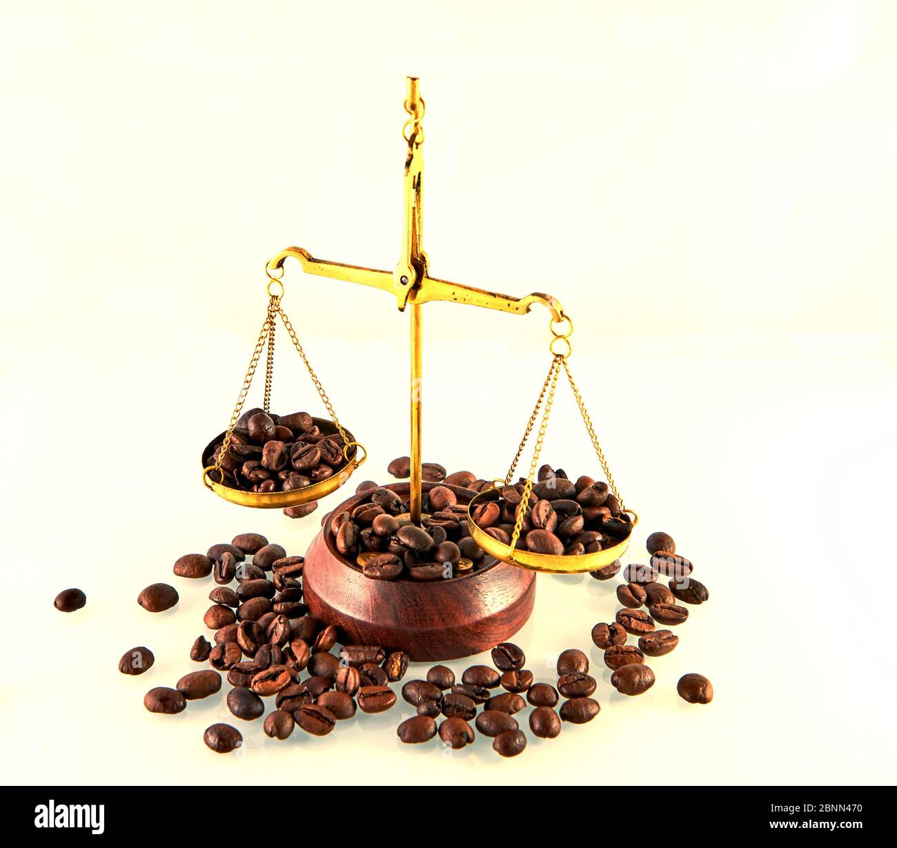 Thème du café avec des échelles en laiton encore la vie sur fond blanc. Grains de café sur les balances. Banque D'Images