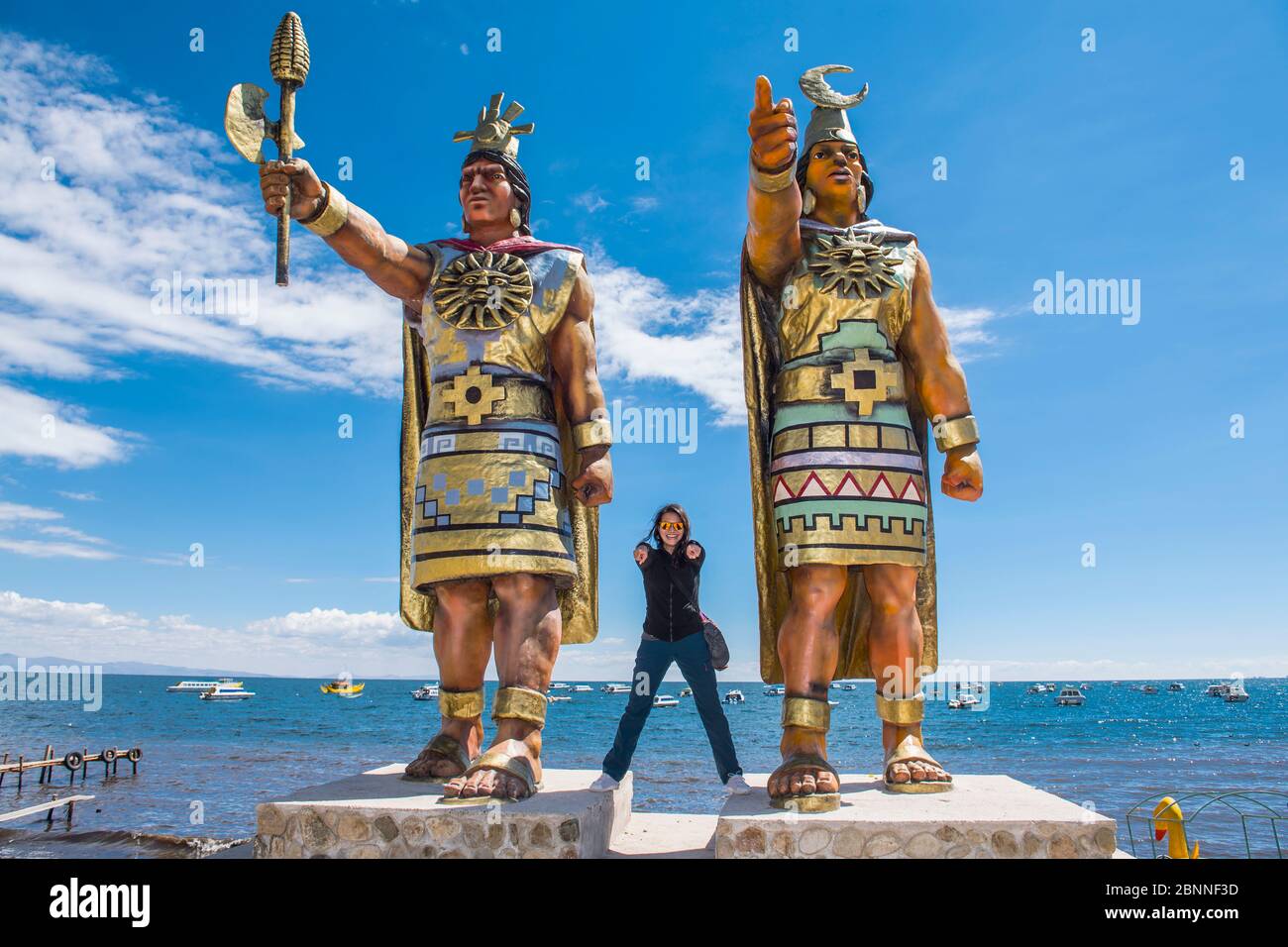 Femme posant à des statues de Dieu du Soleil et de la Déesse de la Lune, Lac Titicaca Banque D'Images