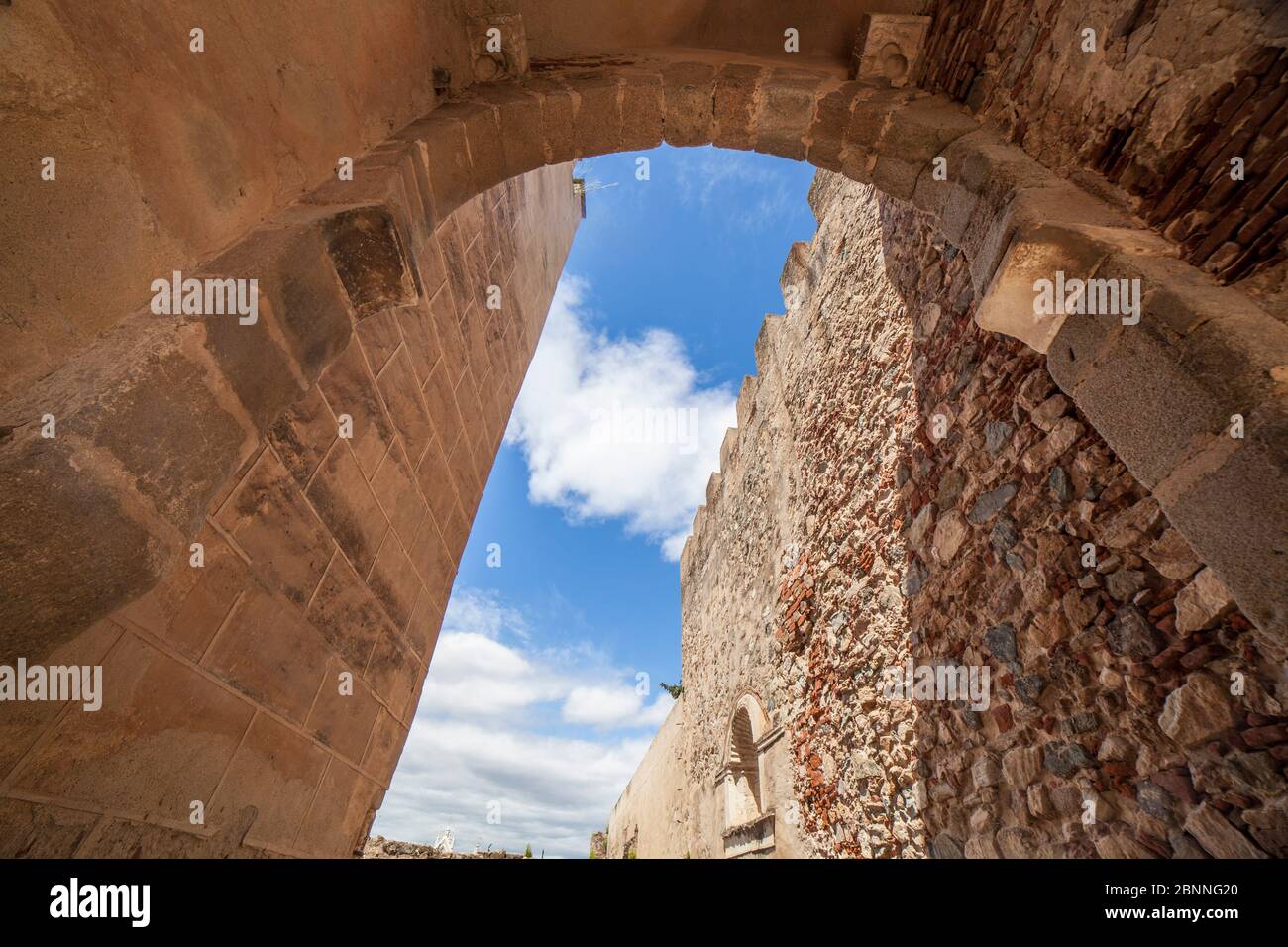 Porte de la capitale à Badajoz Alcazaba de l'époque d'Almohade, Extremadura, Espagne. Arc en fer à cheval pointu fait avec des cendriers en granit Banque D'Images