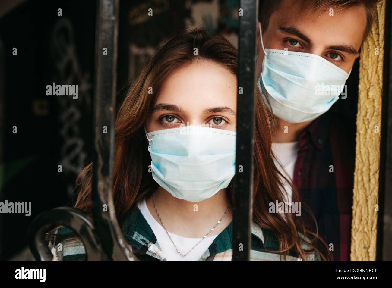 Coronavirus Covid-19. Séjour à la maison concept de sécurité. Jeune couple portant des masques de protection Banque D'Images