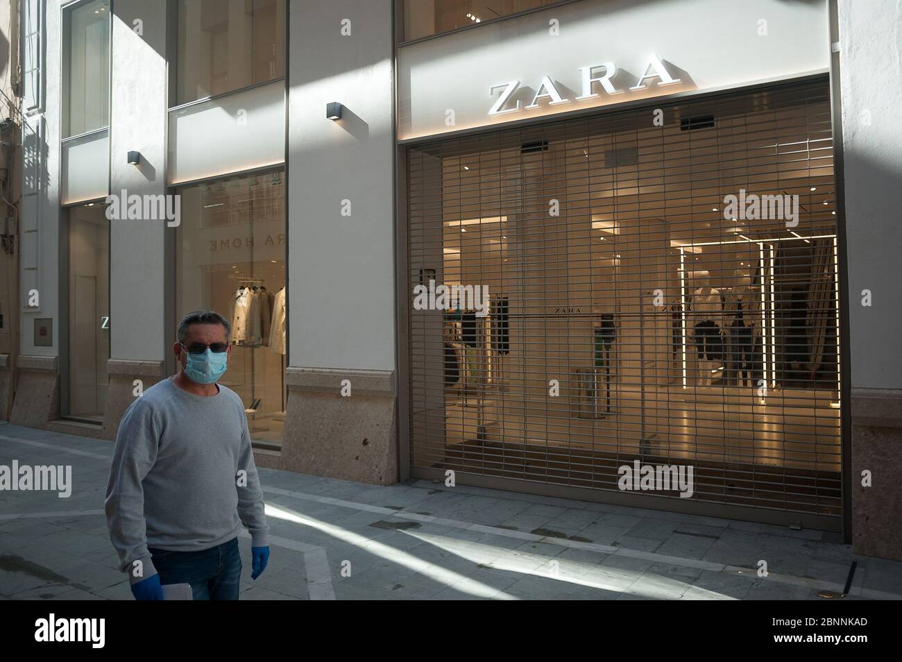 Un homme portant un masque facial passe devant un magasin fermé de Zara  pendant le confinement partiel après le début de la phase 1 dans certaines  villes.l'Espagne passe par le plan de