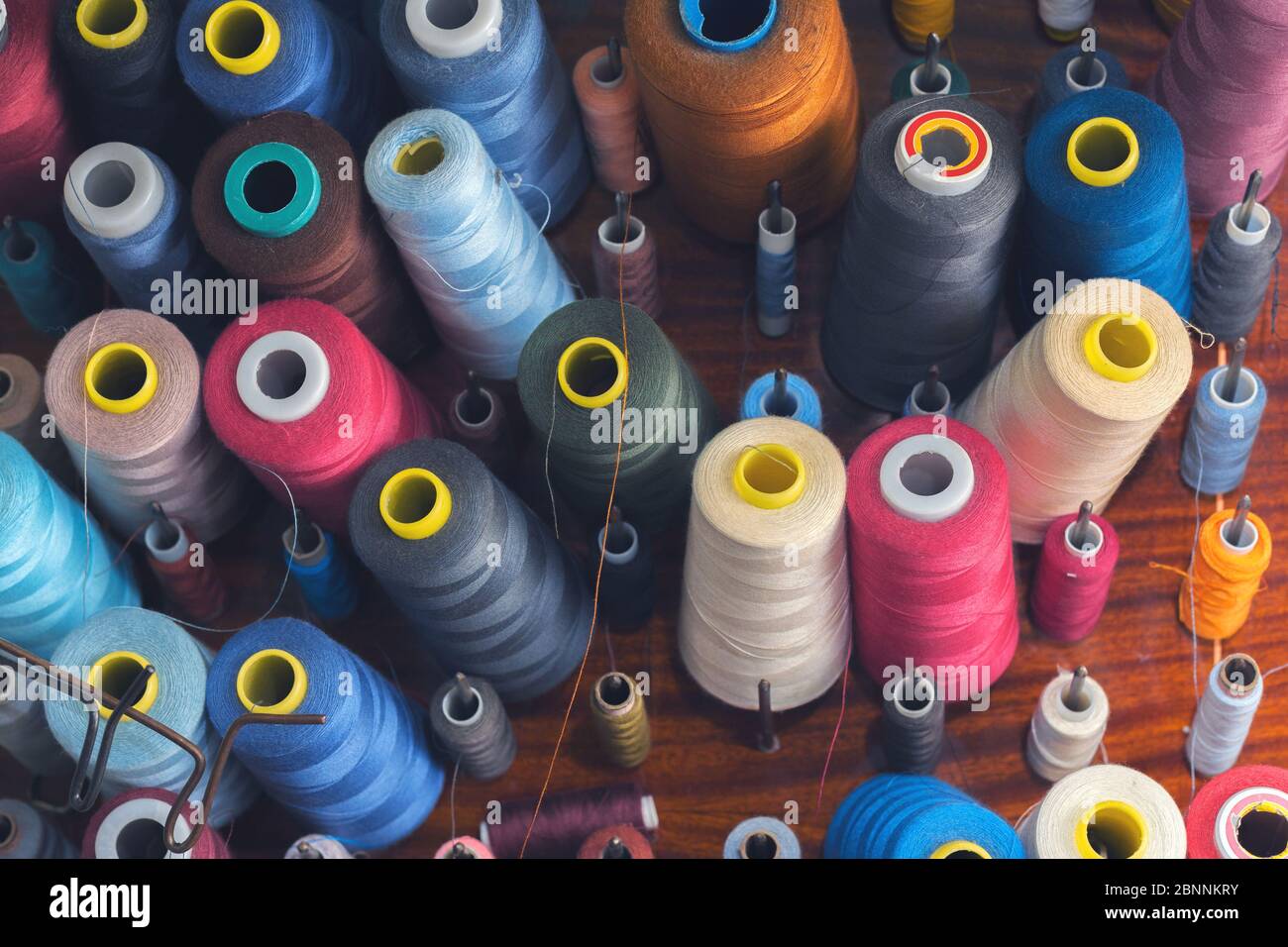 Fil de couleur sur bobines dans un atelier de couture. Concept de l'industrie du vêtement Banque D'Images