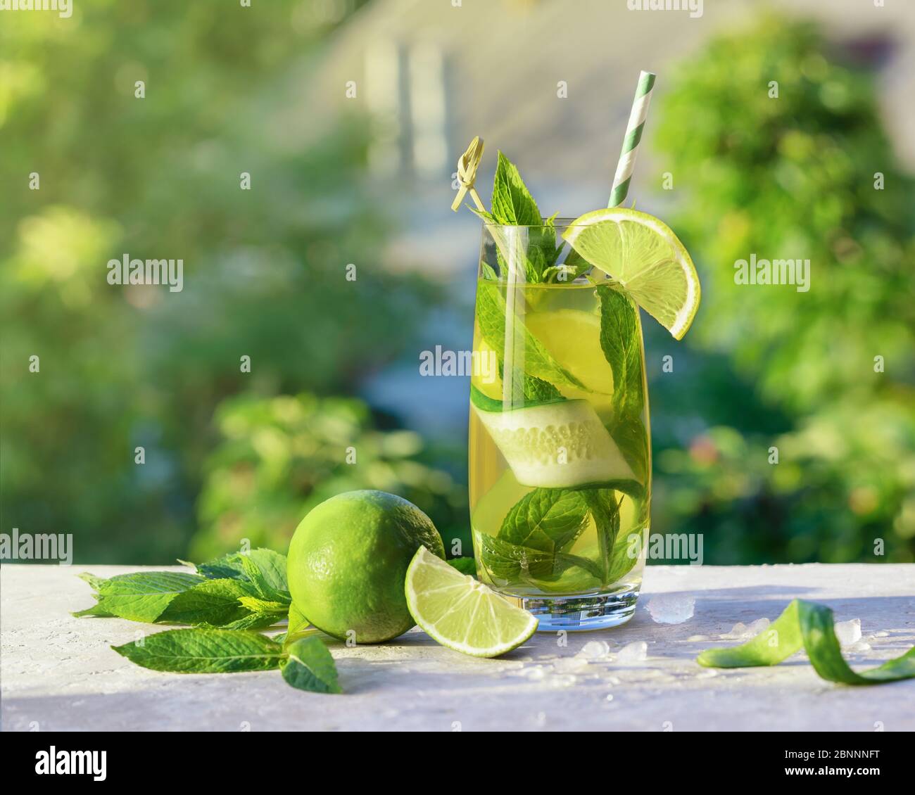 Limonade ou cocktail mojito avec citron vert, concombre et menthe, boisson rafraîchissante froide ou boisson avec glace, extérieur. Eau froide de détox avec du citron et du papier Banque D'Images