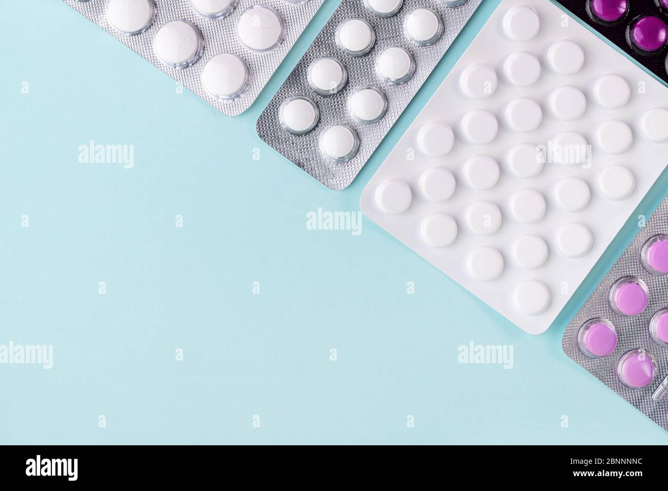 Épidémie de coronavirus covid-19. Comprimés sous blister, médicament sur fond bleu. Concept de pharmacie, médecine, soins de santé. Analgésique, vitamine, antibioti Banque D'Images