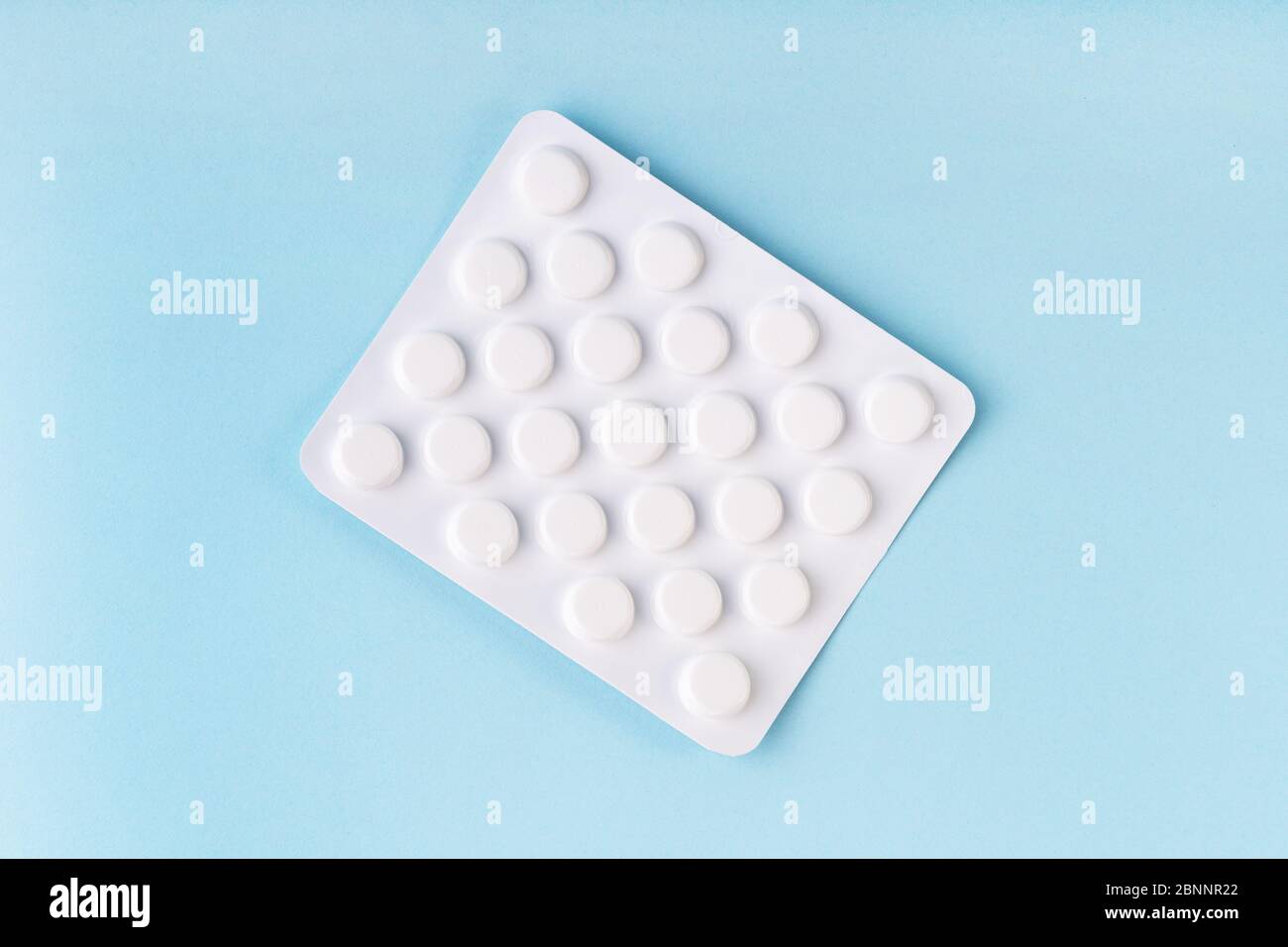 Comprimés sous blister, médicament sur fond bleu. Pharmacie, concept de soins de santé. Traitement du coronavirus. Concept de pharmacie. Surdosage en comprimés. Banque D'Images