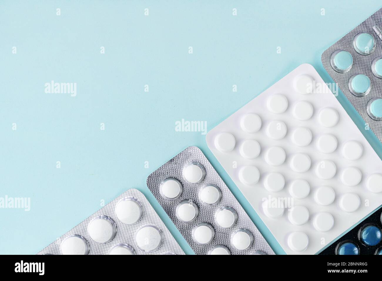 Comprimés sous blister, comprimés sur fond bleu. Pharmacie, concept de soins de santé. Traitement du coronavirus. Concept de pharmacie. Surdosage en comprimés. Banque D'Images