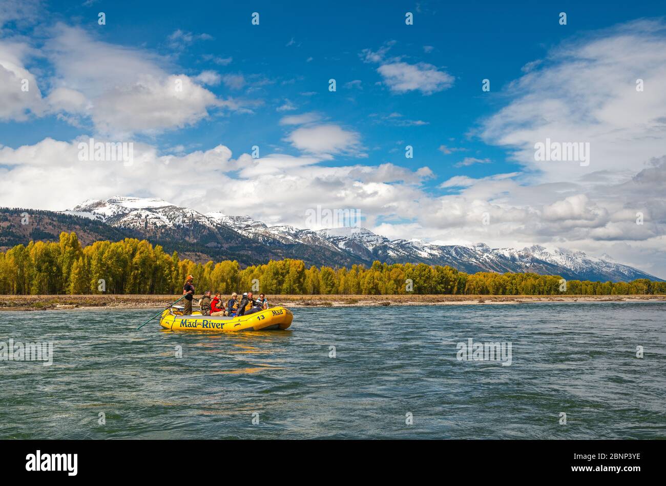 Les gens font du rafting sur la rivière Snake avec la chaîne de Grand Teton dans la neige et le parc national en arrière-plan dans l'État du Wyoming, aux États-Unis. Banque D'Images