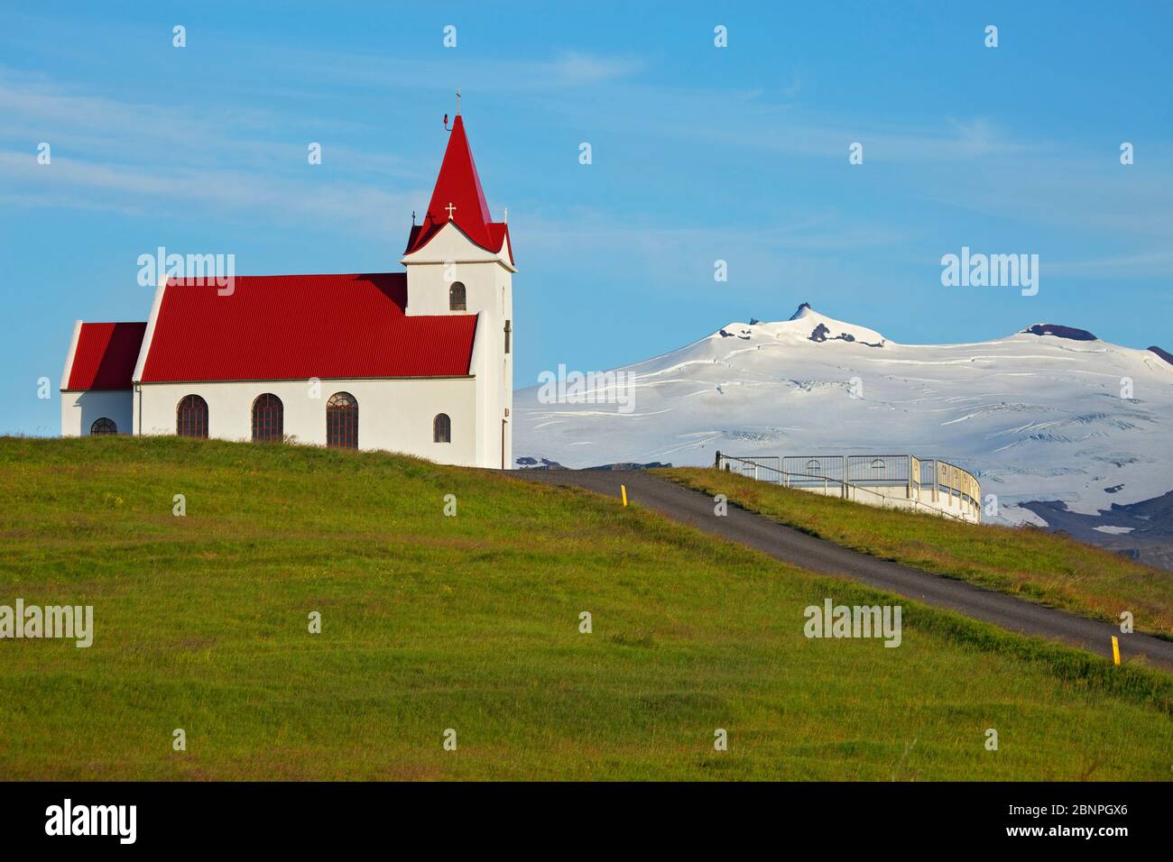 L'Ingjaldshoelskirkja près de Rif, sur la péninsule islandaise de Snaefellsnes, a été construite en 1903 et est considérée comme la plus ancienne église en béton du monde et comme une résidence d'un an de Christophe Colomb. Derrière elle se trouve le Snaefelsdsjoekull. Banque D'Images