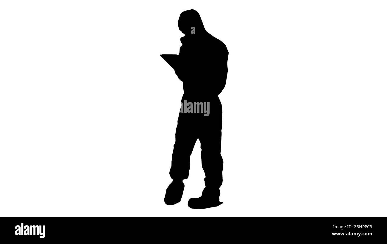 Silhouette Healthcare, un employé portant une combinaison de noisettes, travaillant sur une tablette numérique. Banque D'Images