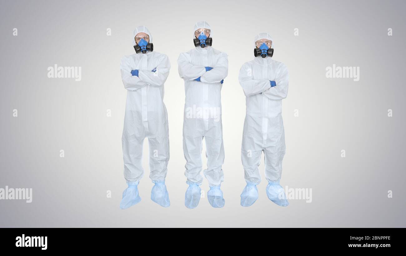 Trois médecins en vêtements de protection se plient les mains équipe travaille sur fond dégradé. Banque D'Images