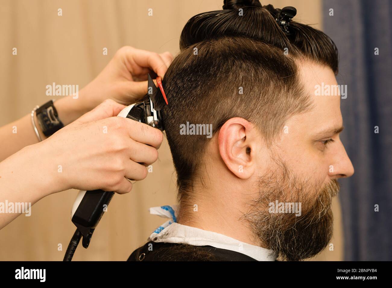 Rasoir électrique coupe de cheveux pour hommes. Main de coiffeur rasse les  cheveux avec un rasoir électrique. Hipster homme obtient une coupe de  cheveux tendance avec une tondeuse à cheveux et un