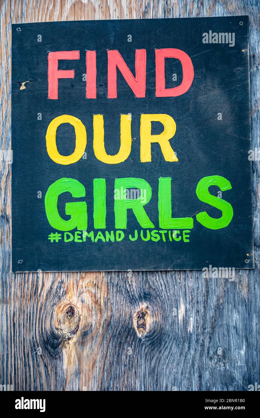 Trouvez l'affiche de nos filles sur un fond de bois abîmé exigeant la justice pour les écolières de Chibok kidnappées au Nigeria dont certaines sont encore portées disparues cinq ans plus tard. Banque D'Images