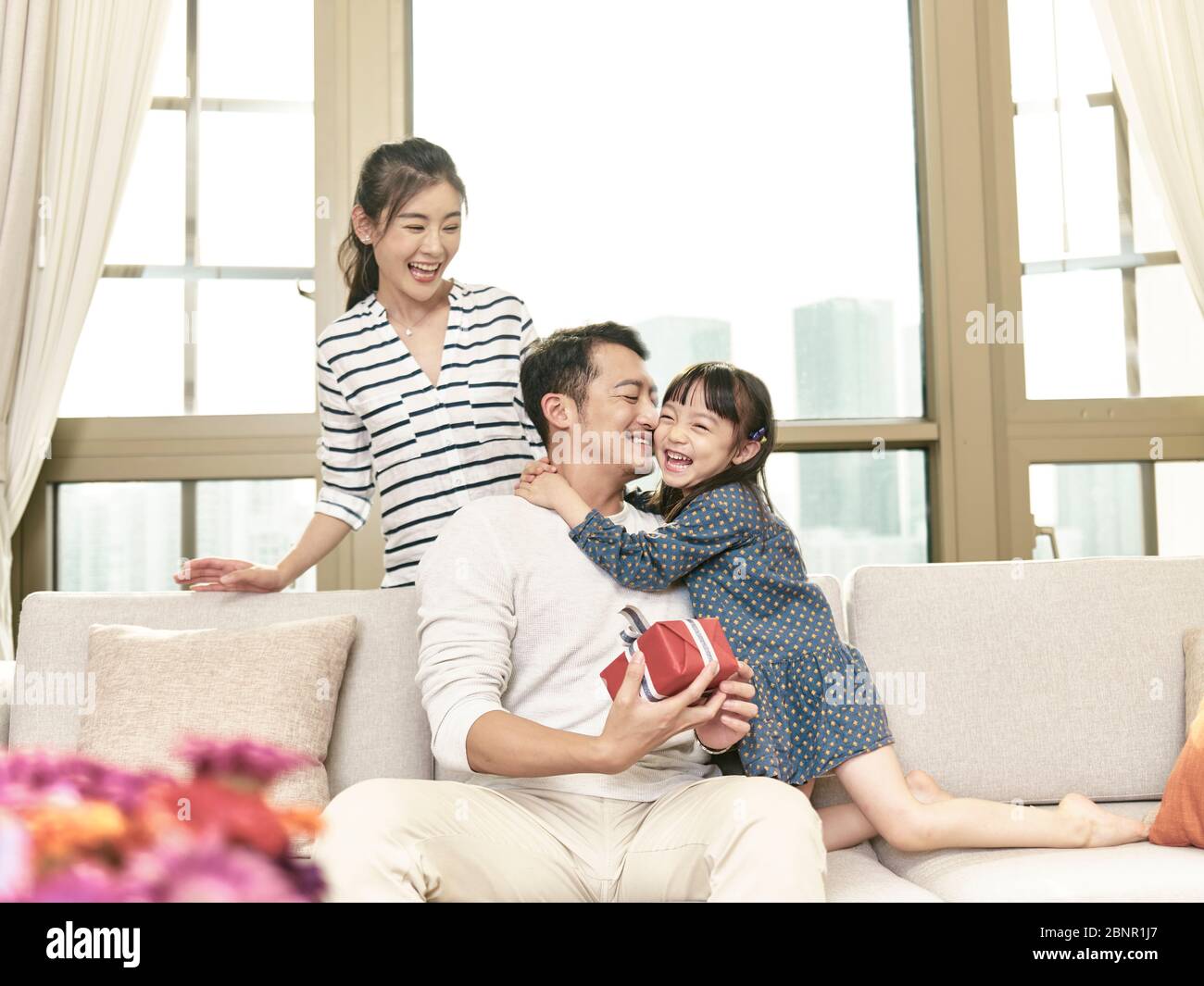petite fille asiatique embrassant le père après avoir donné un cadeau Banque D'Images