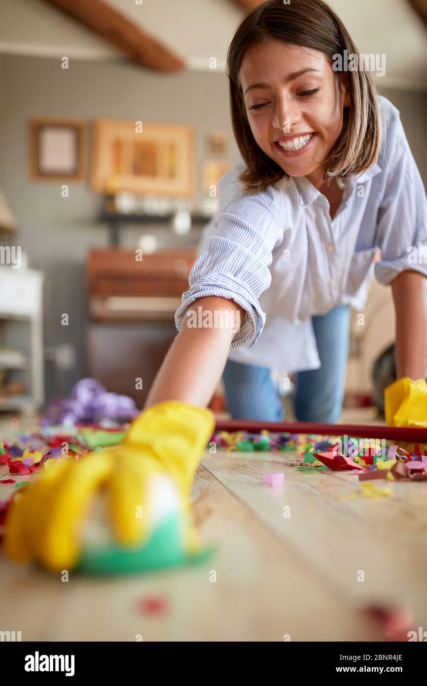 jeune femme souriante qui nettoie la maison après une fête d'anniversaire - gros plan Banque D'Images