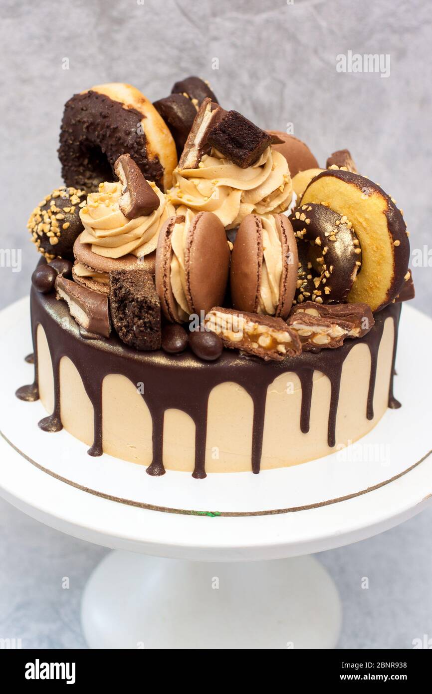 Gâteau au beurre d'arachide décoré de chocolat noir fondu, beignets, en-cas  de chocolat, pâtes à gâteau, macarons et bonbons. Fond gris Photo Stock -  Alamy
