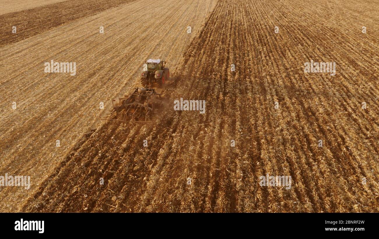 Vue de dessus du tracteur labourage dans le champ après la récolte. Banque D'Images Vue de dessus du tracteur labourage dans le champ après la récolte. Banque D'Images