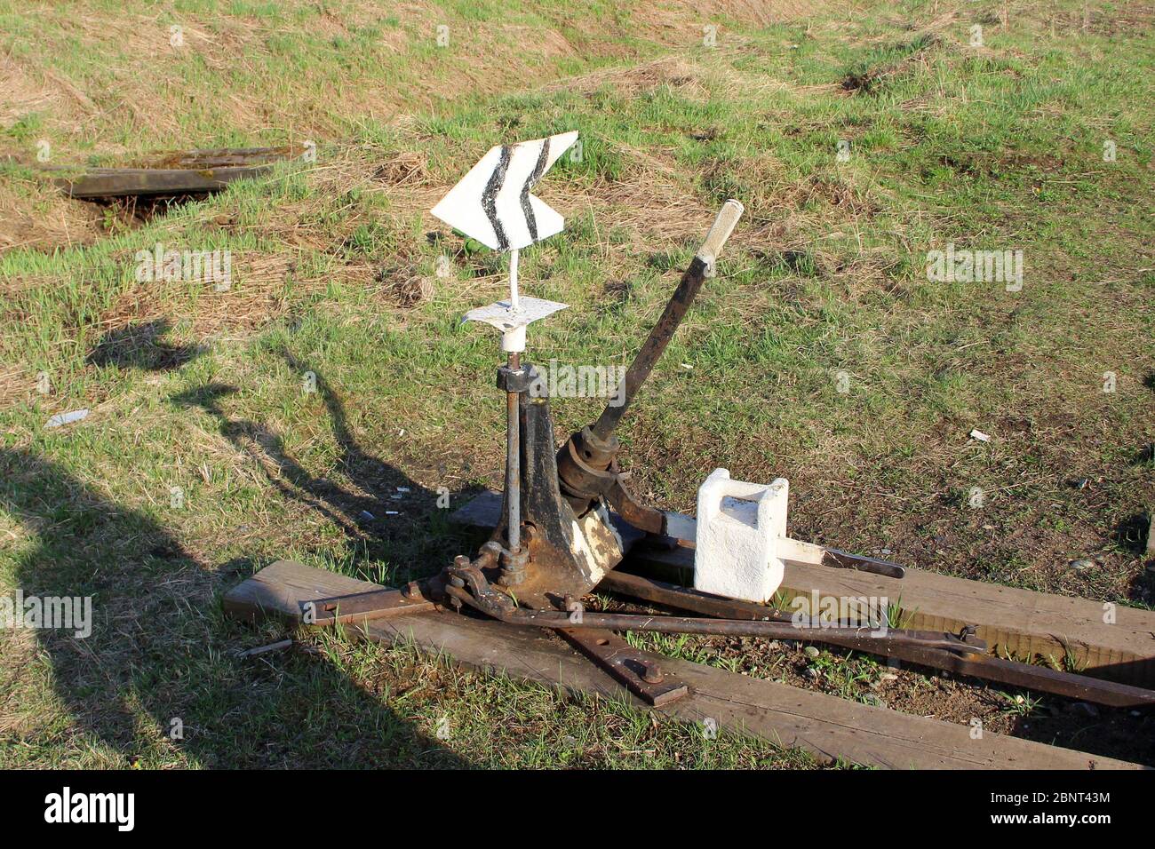 Flèche de chemin de fer en noir avec un levier et un pointeur en Russie. Dispositif de transfert de rails aux intersections pour les trains. Élément technique de l'industrie ferroviaire. Banque D'Images
