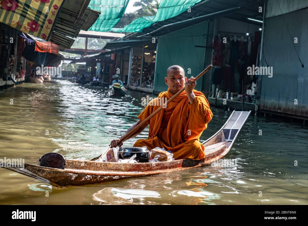 Ratchaburi, Damnoen Saduak / Thaïlande - 11 février 2020 : le moine bouddhiste sculpte le bateau dans le marché flottant de Damnoen Saduak. Le marché flottant est le plus Banque D'Images