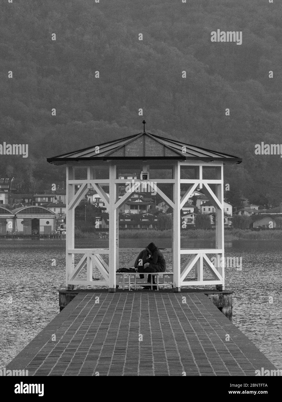 paire d'amoureux sous un belvédère sur la jetée d'un lac, image en noir et blanc Banque D'Images